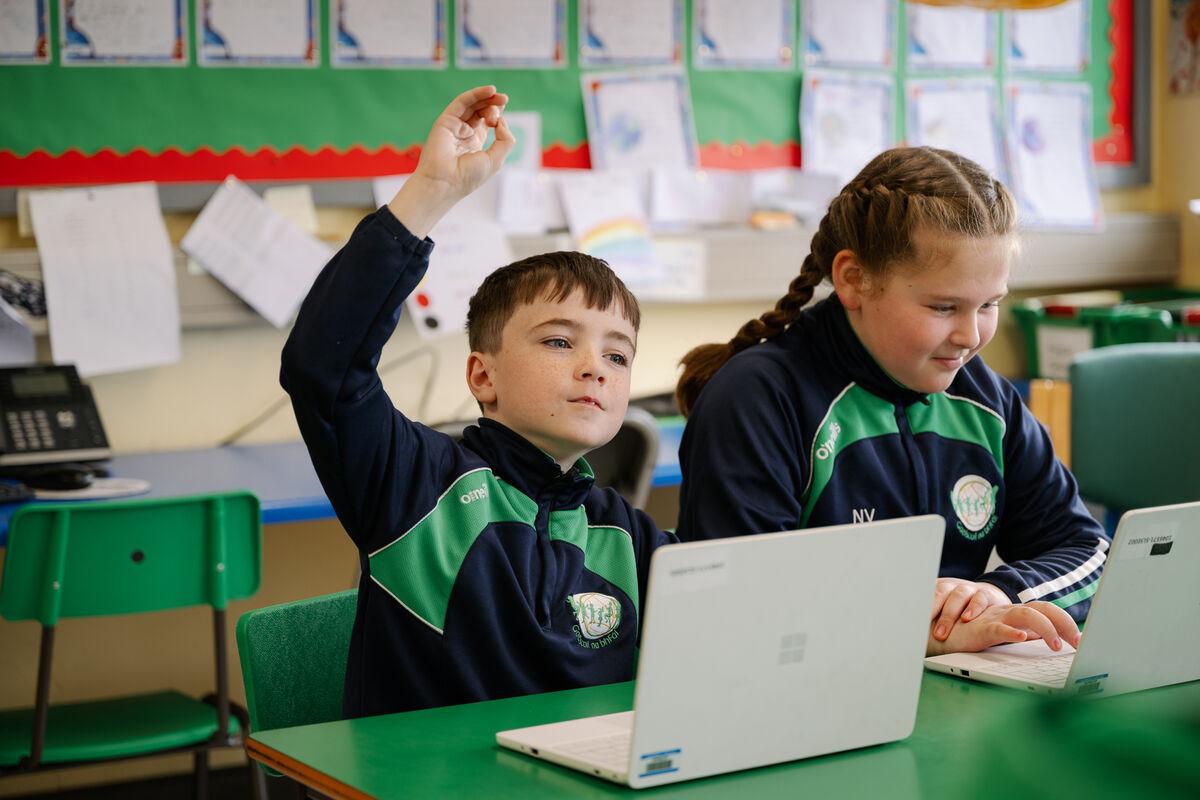Páistí ag úsáid ríomhairí glúine sa rang / Children using laptops in class