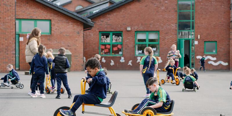 Páistí ag foghlaim agus ag súgradh inár suíomh scoile Ghaeilge bheo bríomhar / Children learning and playing in our vibrant Irish-language school environment